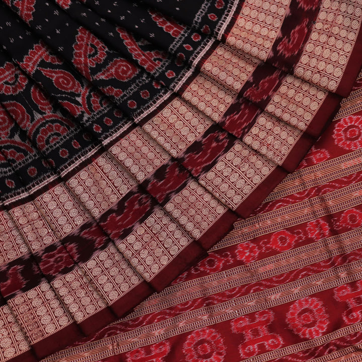 An approximately 150 cm wide handloom black silk Sambalpuri Saree with maroon motifs, captured in a close-up to depict its rich fabric texture.