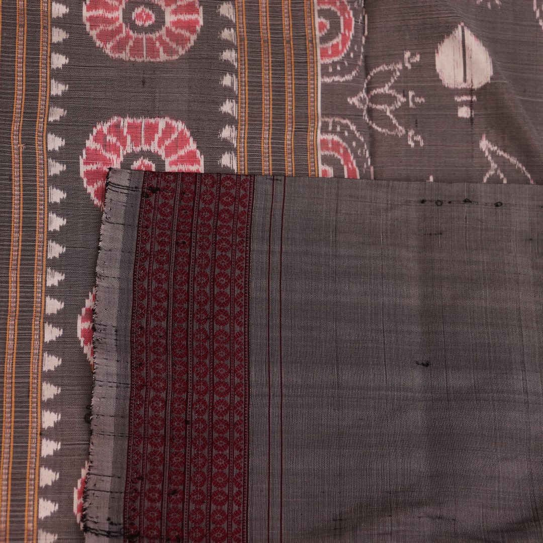 Close-up of a multicolored silk Sambalpuri saree fabric showing the intricate handloom texture and motifs.