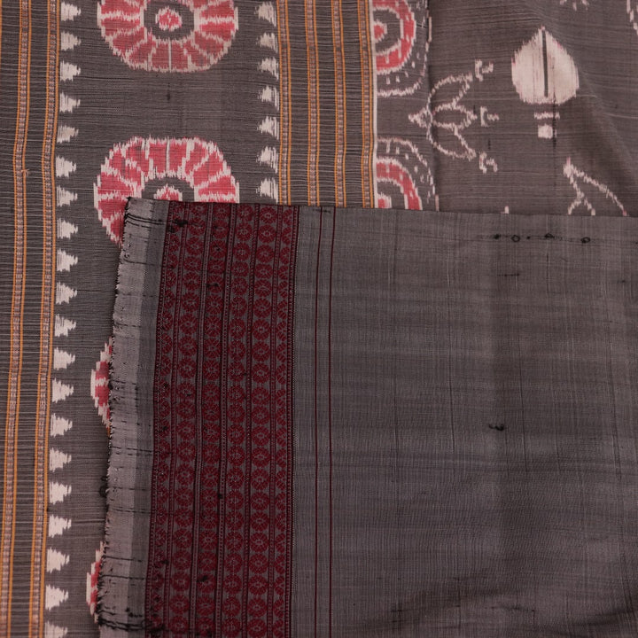Close-up of a multicolored silk Sambalpuri saree fabric showing the intricate handloom texture and motifs.