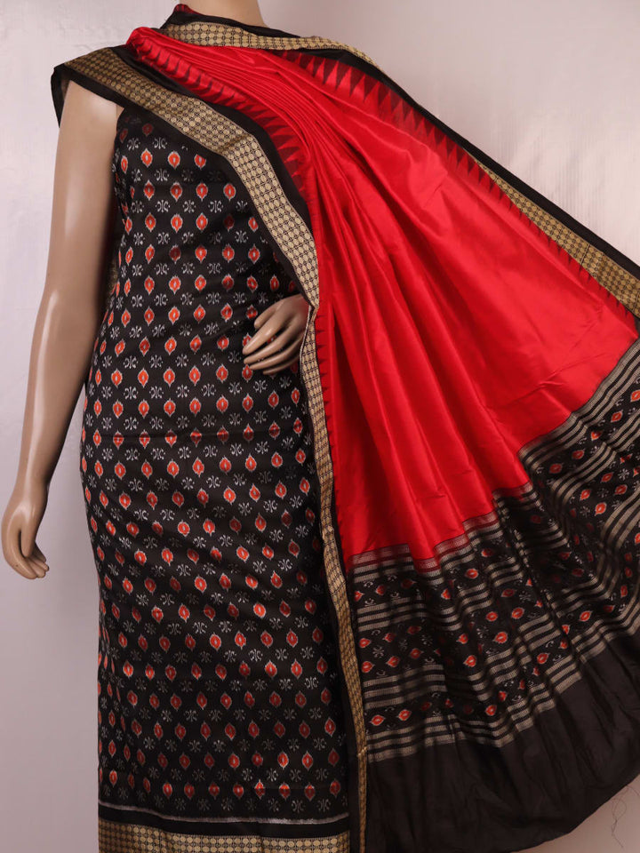 Detail of black Sambalpuri silk blouse piece from dress material, featuring red motifs.