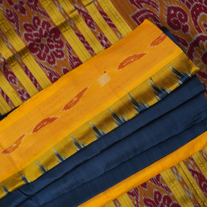 Model styling a blue and yellow Khandua silk saree with traditional butta work and border.