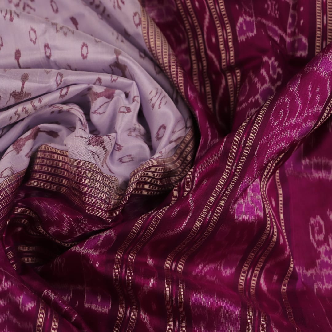 Close-up of silk fabric with intricate Sambalpuri motif design in multicolor and purple hues