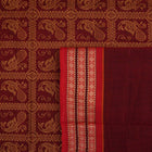 Full view of the maroon Bomkai cotton saree with red borders and small butta motifs laid out flat.