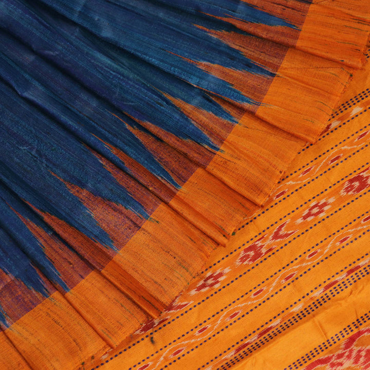 Close-up showcasing the intricate blue tussar silk fabric with a plain pattern and yellow accent hues.