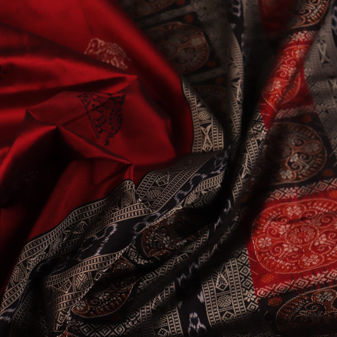 Detailed texture of handwoven Bomkai silk saree fabric in maroon and black with butta pattern.