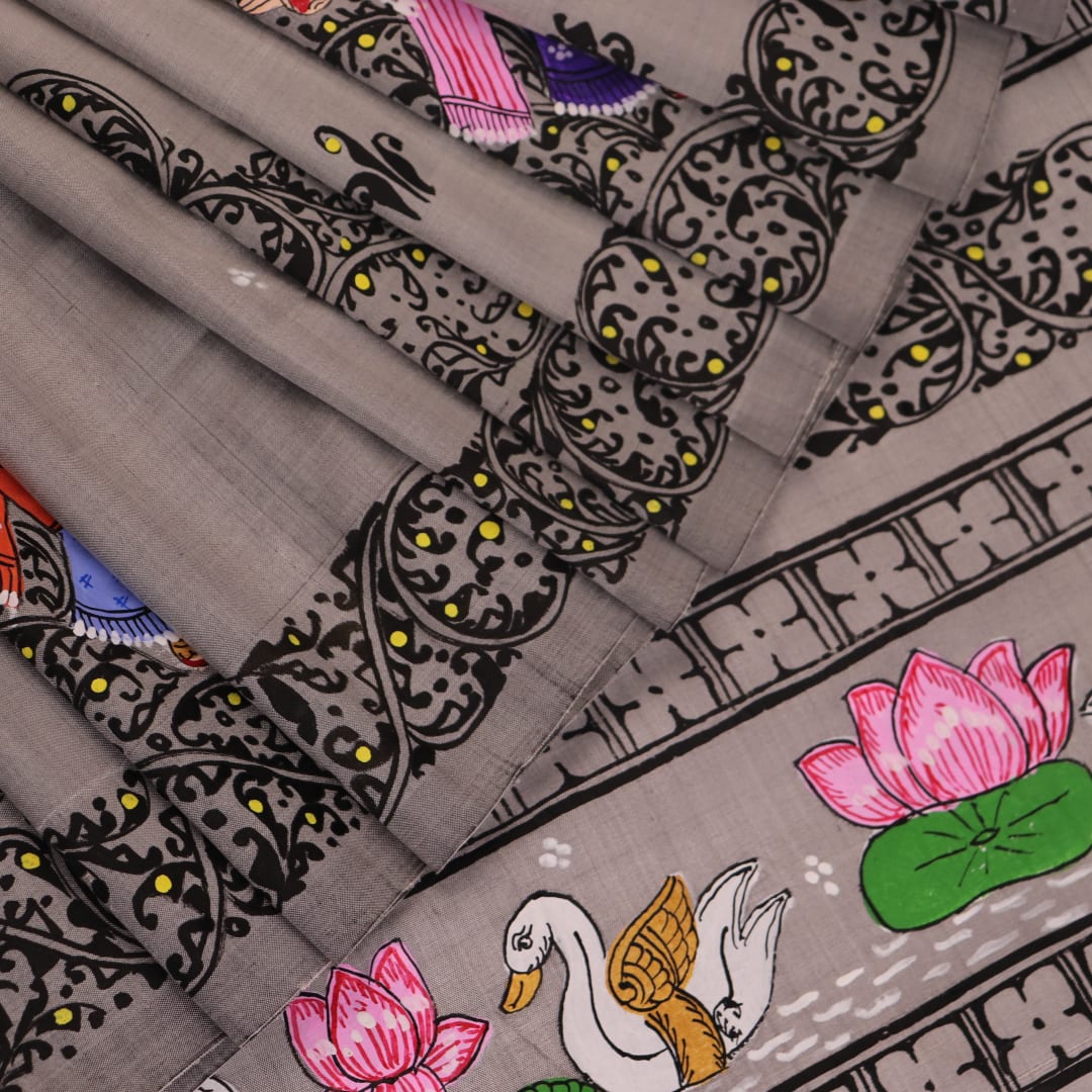 Close-up of grey silk Patachitra saree fabric showing hand-painted texture and intricate weave detail.