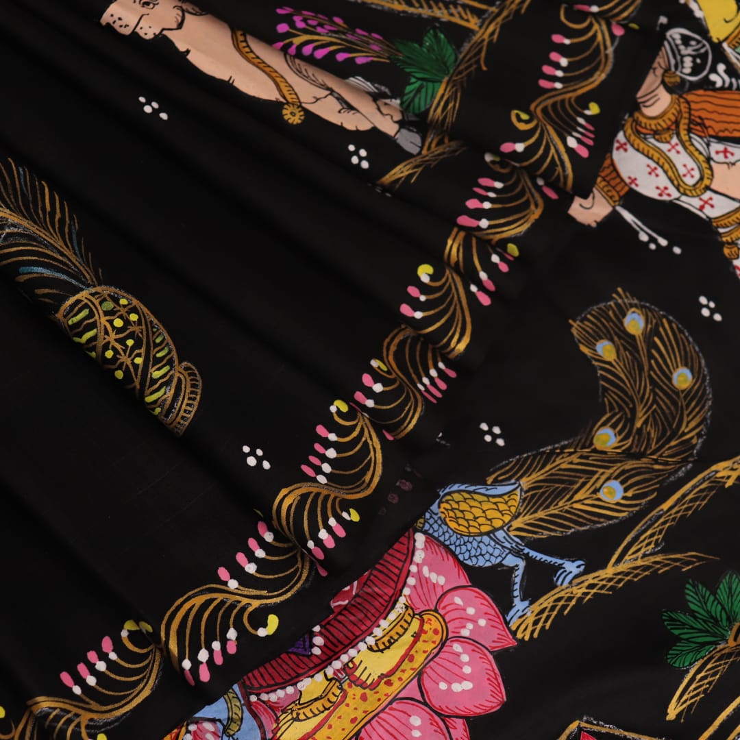 Close-up of black silk Patachitra saree fabric texture showing hand-painted details.