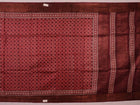 Close-up of maroon Tussar silk saree fabric, revealing its characteristic slub texture and printed details.