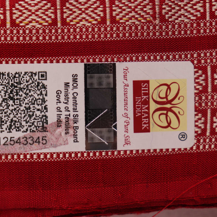 Close-up of grey Sambalpuri silk saree fabric showing intricate woven motifs and texture.