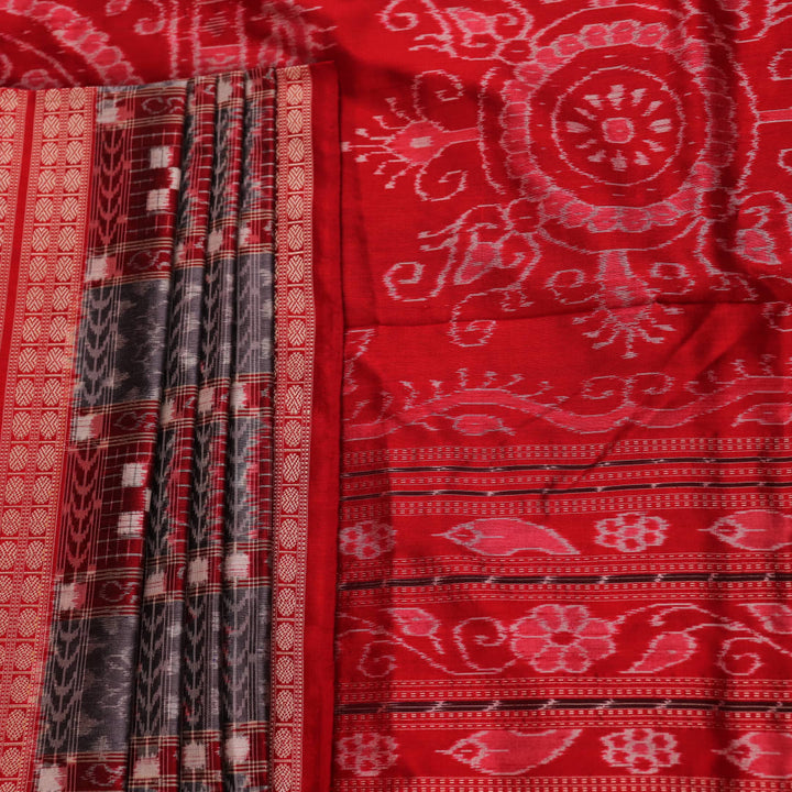 Close-up of grey Sambalpuri silk saree fabric showing intricate woven motifs and texture.