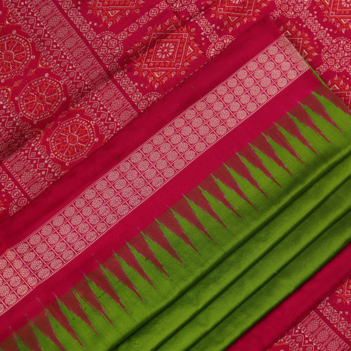 Textured close-up of green Bomkai silk saree fabric, revealing intricate weave and magenta butta pattern.