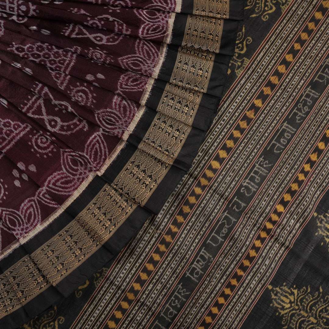 Micro close-up of the maroon Sambalpuri silk fabric, revealing its luxurious texture and handloom weave.