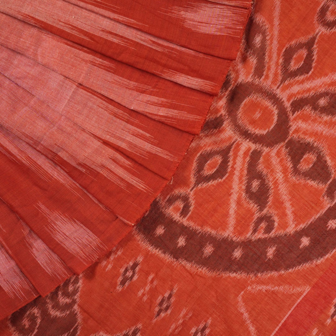 Professional styling view of a rust Sambalpuri cotton saree draped on a model for an elegant ethnic look.