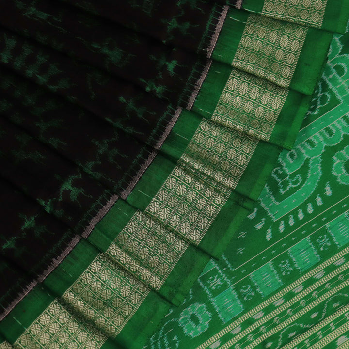 Close-up showcase of the exquisite silk texture with intricate motifs in a black and green Sambalpuri saree.