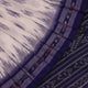 Model wearing a white Sambalpuri cotton saree with blue motifs, showcasing the drape and overall look.