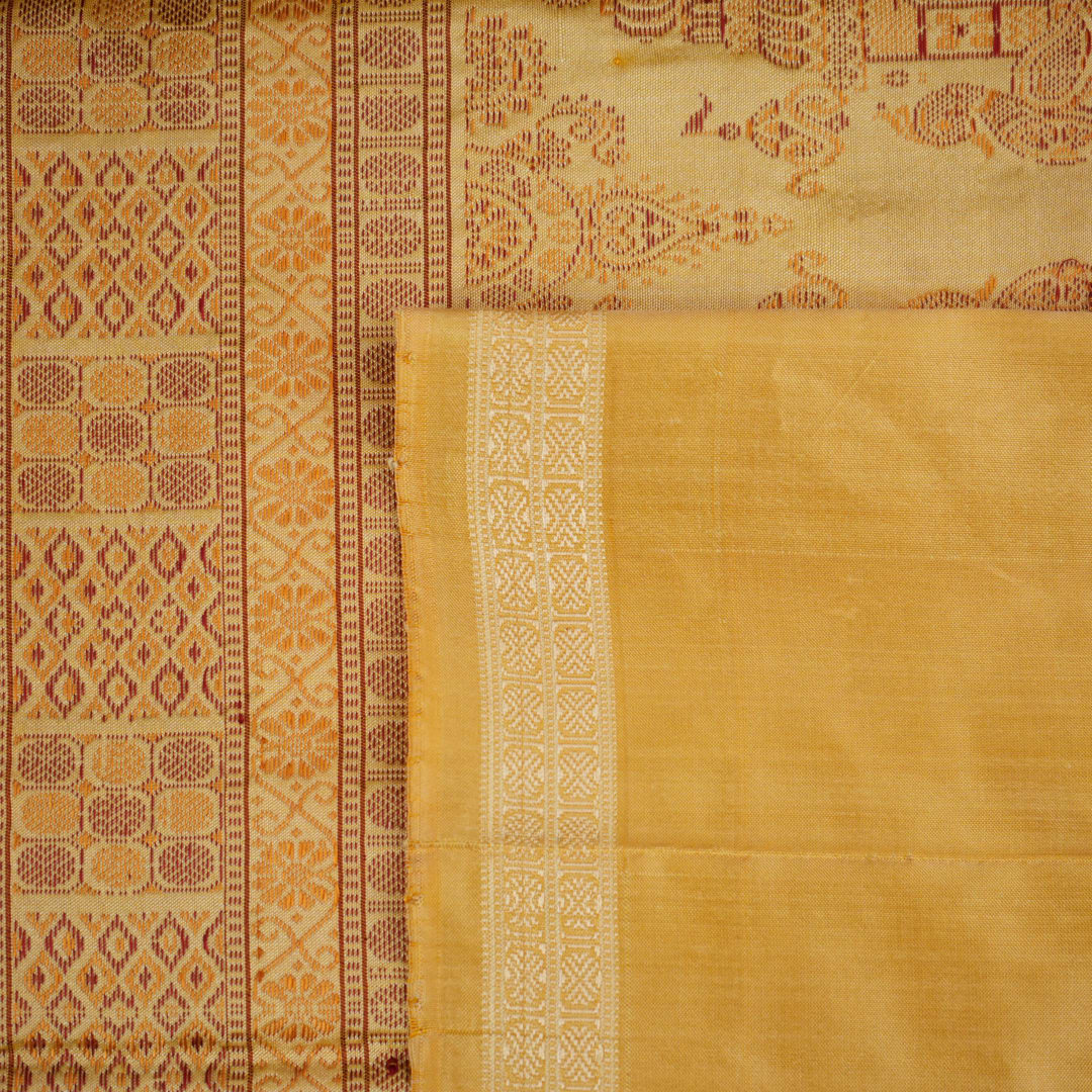 Close-up of the luxurious Bomkai silk saree fabric texture and weave in pink and yellow.