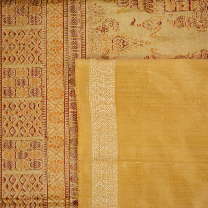 Close-up of the luxurious Bomkai silk saree fabric texture and weave in pink and yellow.