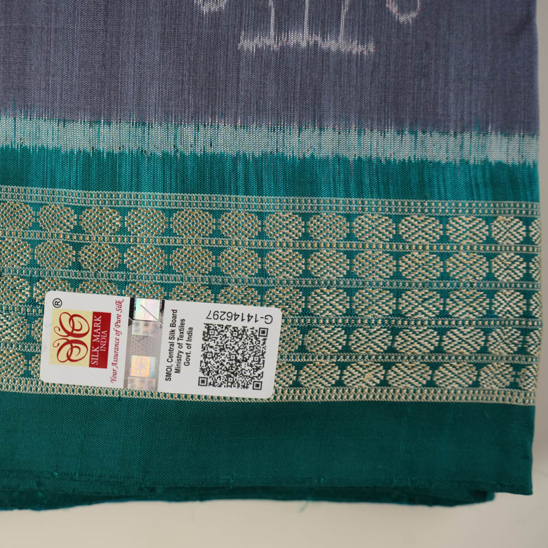 Extreme close-up of grey Sambalpuri silk fabric, revealing its fine handloom texture and weave quality.