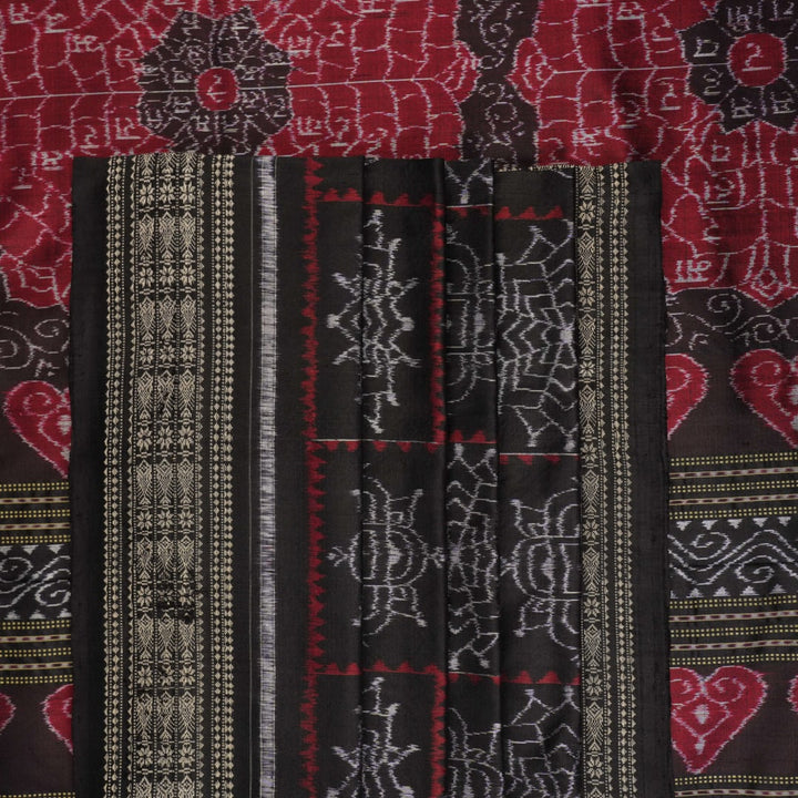 Extreme close-up of black Sambalpuri silk saree fabric, highlighting its luxurious texture and weave.