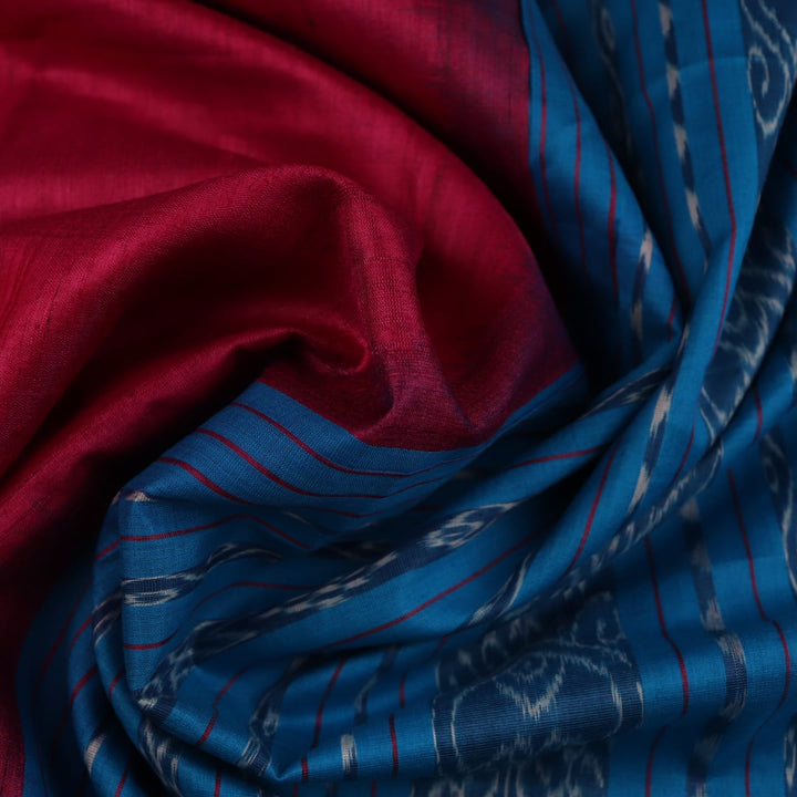 Close-up shot showcasing the textured weave of the tussar silk fabric of a plain pink and blue saree.