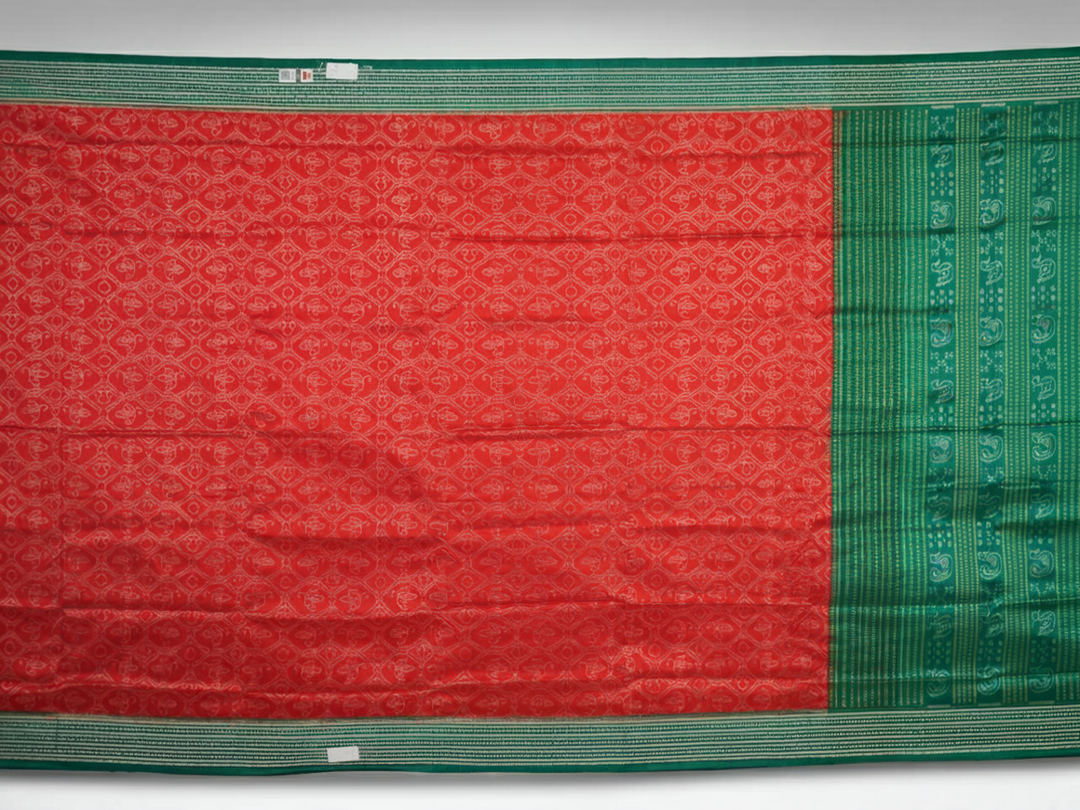 Extreme close-up of the rich orange Sambalpuri silk fabric, highlighting its intricate handloom weave texture.