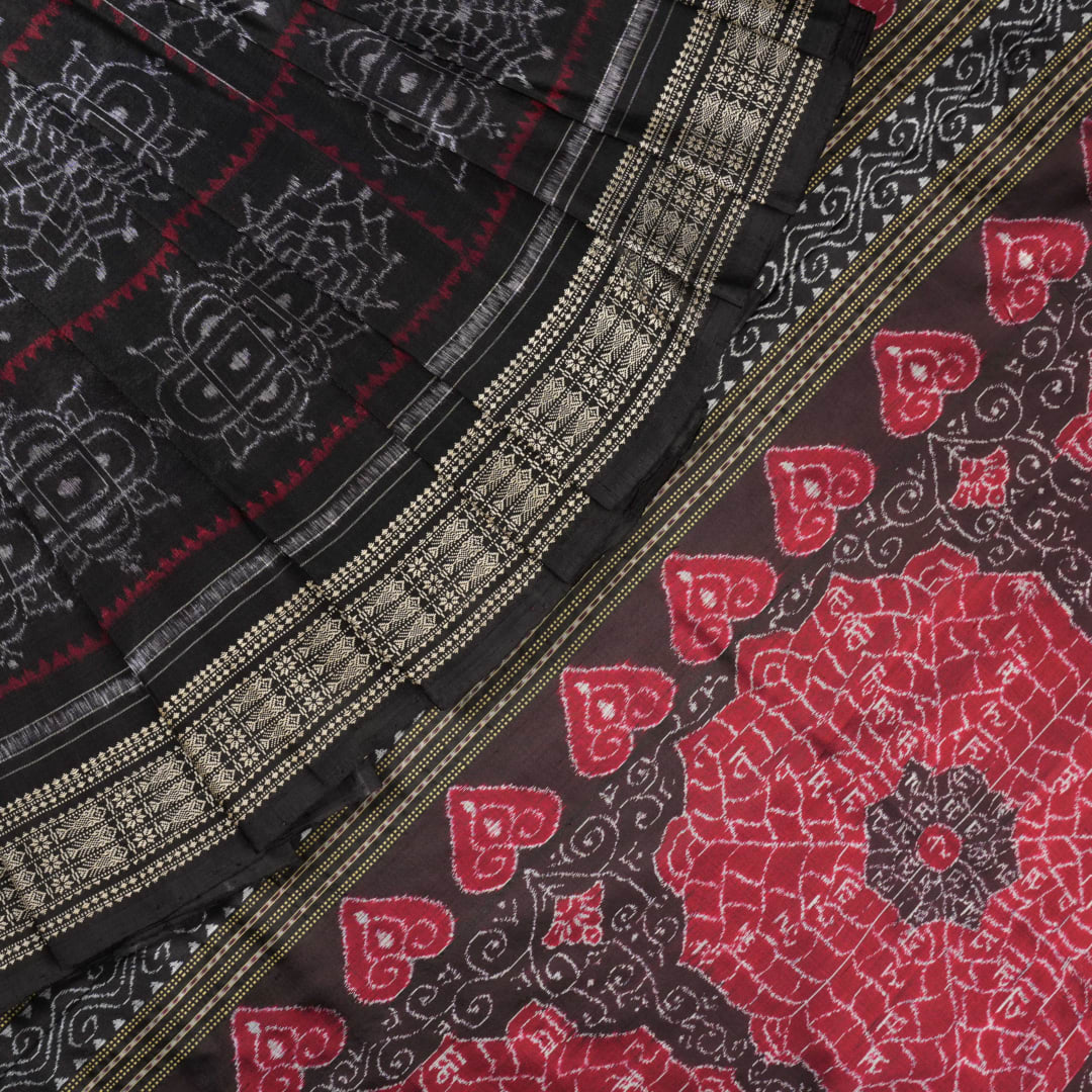 Extreme close-up of black Sambalpuri silk saree fabric, highlighting its luxurious texture and weave.