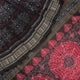 Extreme close-up of black Sambalpuri silk saree fabric, highlighting its luxurious texture and weave.