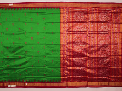 Close-up of luxurious green silk tissue saree fabric, showcasing intricate butta weaving details.