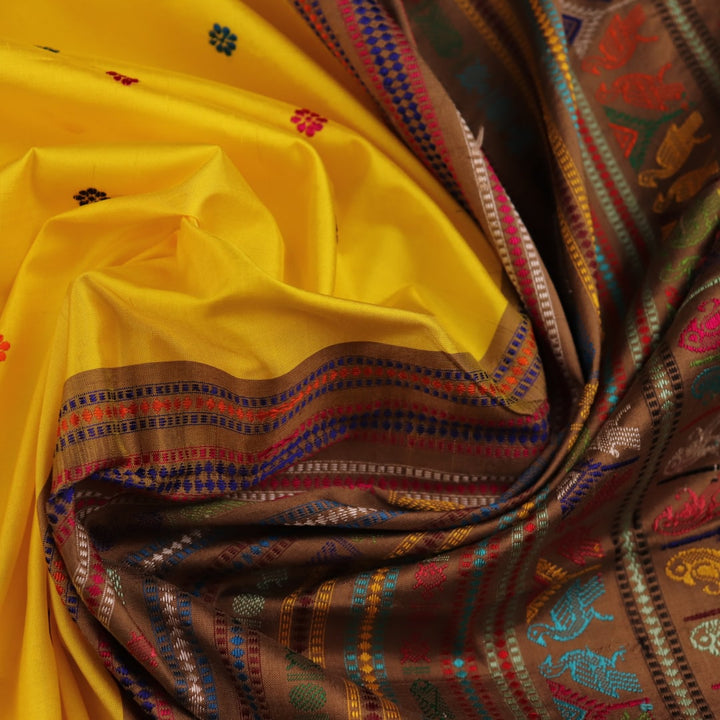 Close-up of Yellow and Brown Silk Saree fabric with Butta pattern