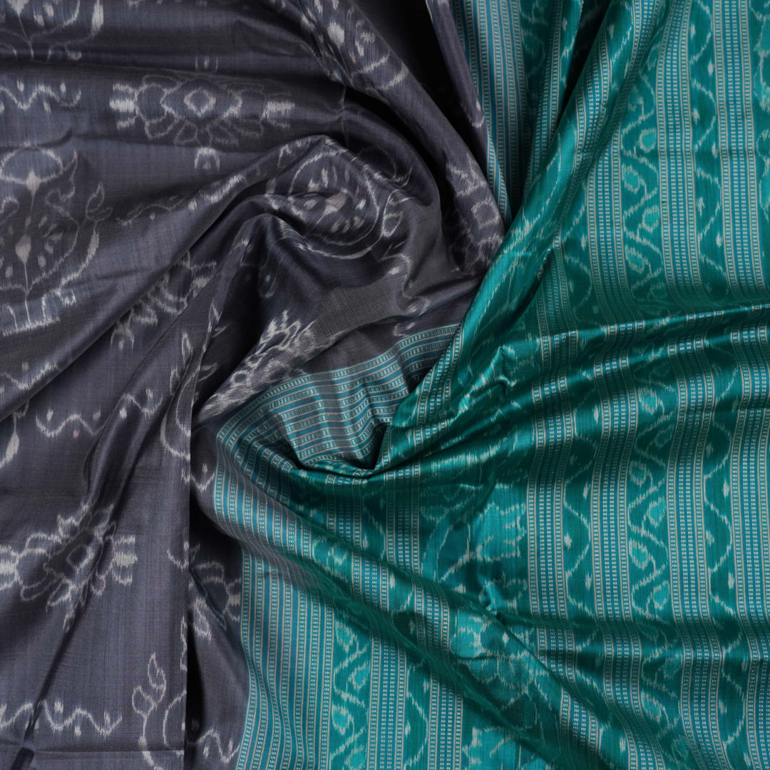 Extreme close-up of grey Sambalpuri silk fabric, revealing its fine handloom texture and weave quality.