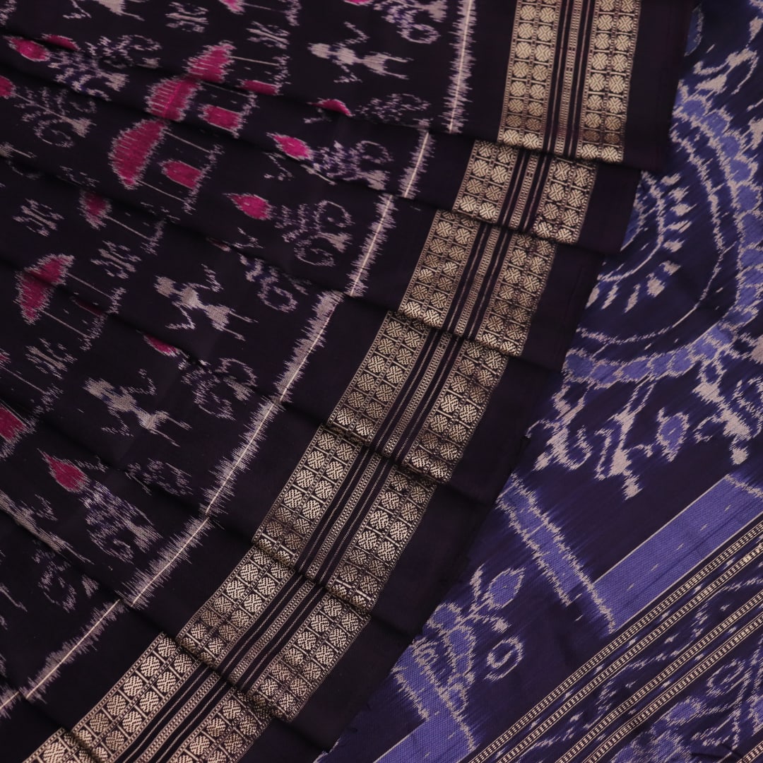 Close-up showing the intricate silk fabric texture of a magenta Sambalpuri saree with multicolor motifs.