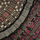 Close-up of the luxurious silk fabric texture and handloom weave of the grey and black Sambalpuri saree.