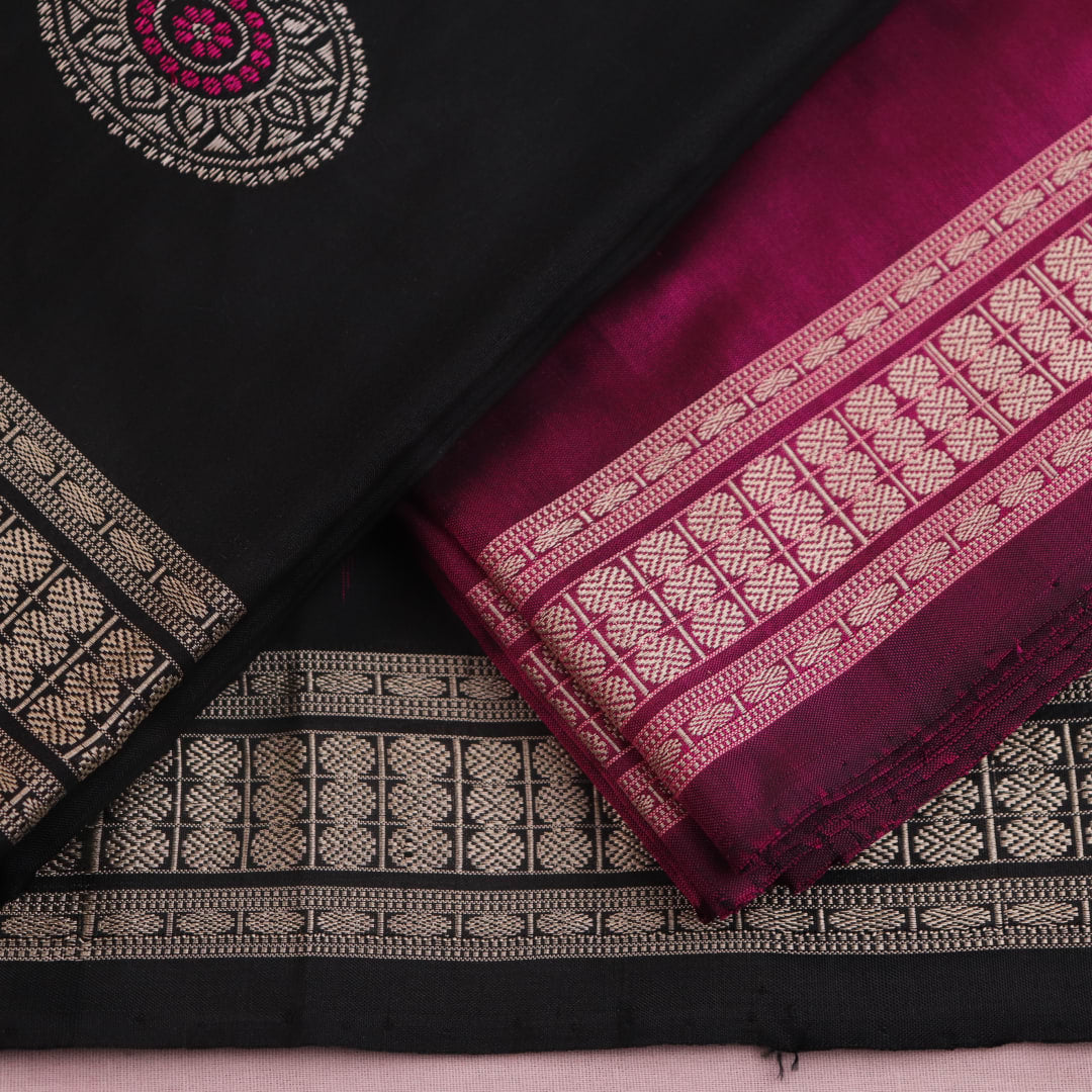 Close-up of Bomkai silk dress material blouse piece, black with magenta butta pattern.