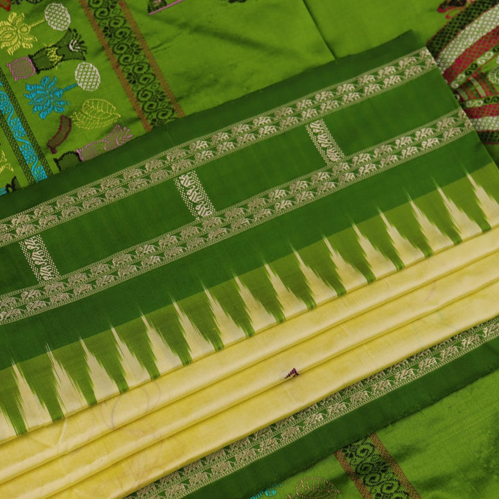 Close-up of cream and green Bomkai Silk Saree fabric texture with butta pattern.