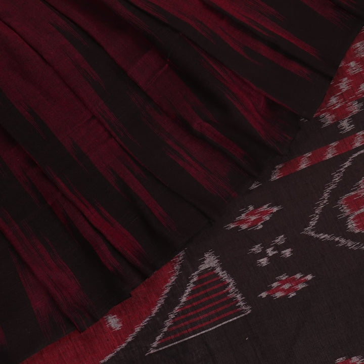 Plain maroon and black Sambalpuri cotton saree, elegantly draped.