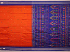 Close-up view of the vibrant orange and blue silk fabric texture with intricate butta pattern