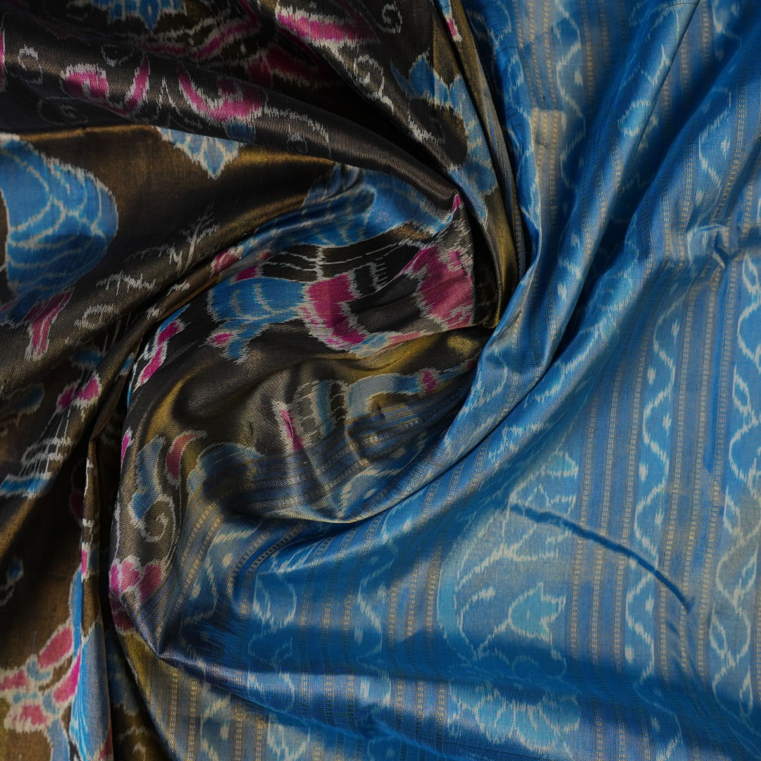 Close-up of Sambalpuri silk saree fabric, revealing rich blue multi-color weave texture and tissue motifs.