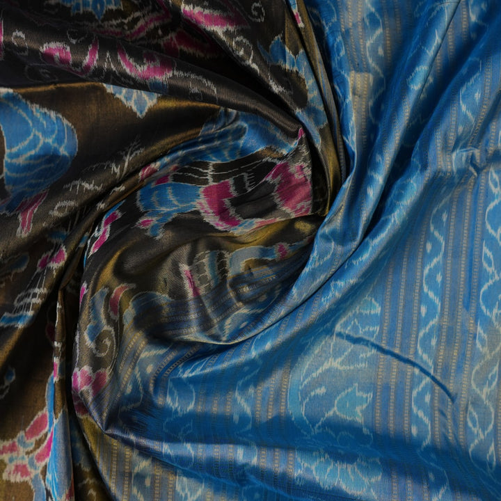 Close-up of Sambalpuri silk saree fabric, revealing rich blue multi-color weave texture and tissue motifs.