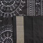 Close-up of grey & black Sambalpuri silk saree fabric, highlighting its rich texture and weave.