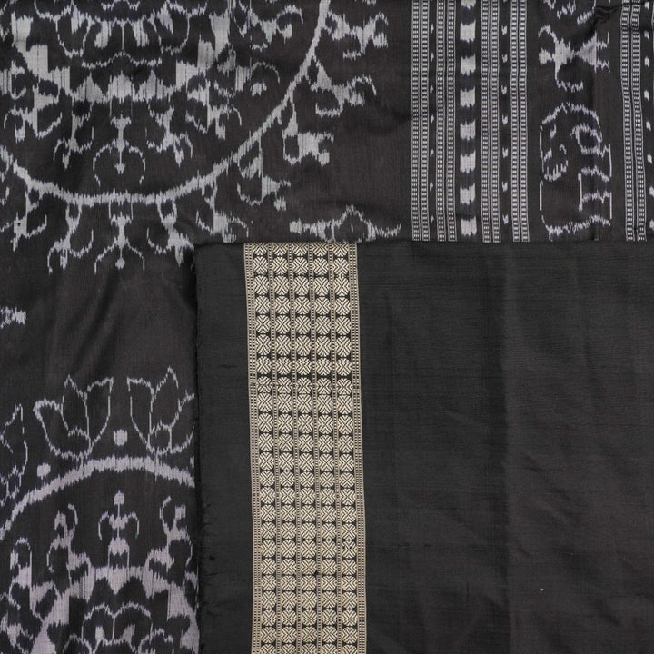 Close-up of grey & black Sambalpuri silk saree fabric, highlighting its rich texture and weave.