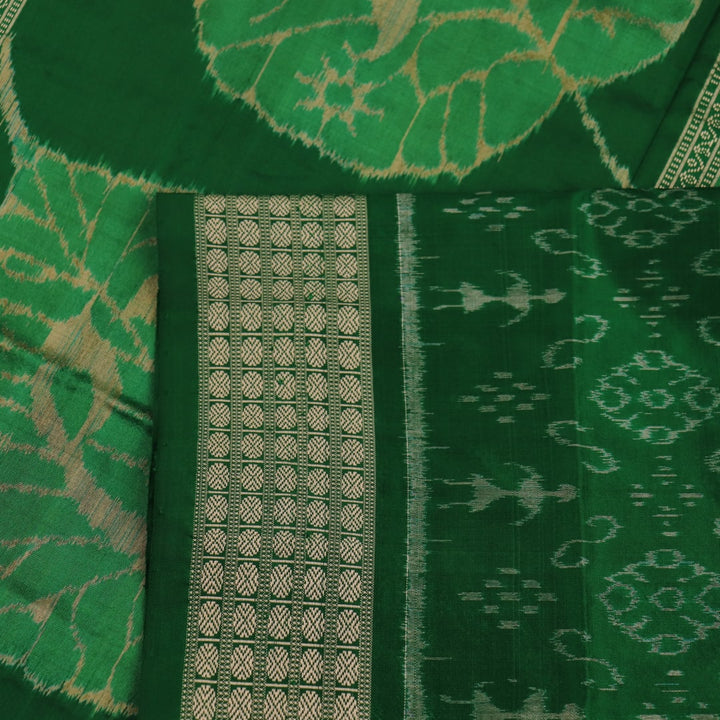 Close-up of the finely textured silk fabric in black, adorned with intricate Sambalpuri motifs in green