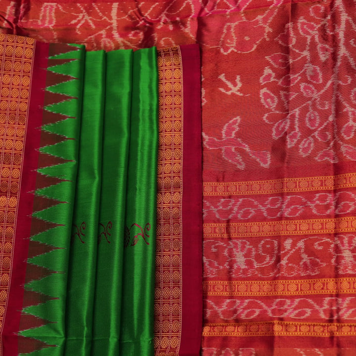 Close-up of luxurious green silk tissue saree fabric, showcasing intricate butta weaving details.