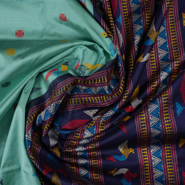 Extreme close-up revealing the rich texture and intricate weave of green Bomkai Silk fabric.