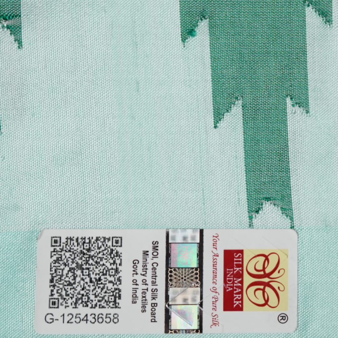 Extreme close-up of the green Sambalpuri silk fabric, revealing its luxurious texture and fine handloom weave.