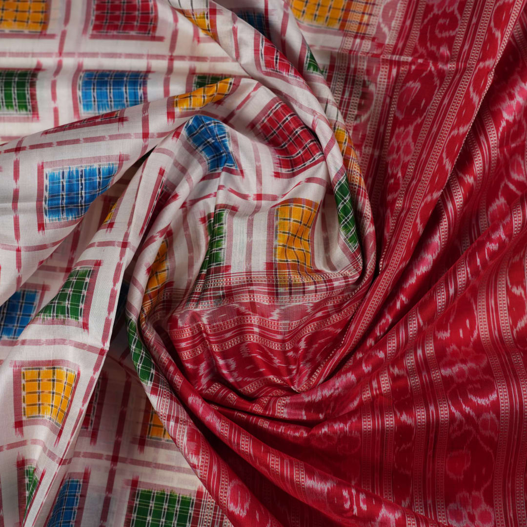 Close-up of the luxurious white Sambalpuri silk saree fabric, highlighting its rich texture and weave.