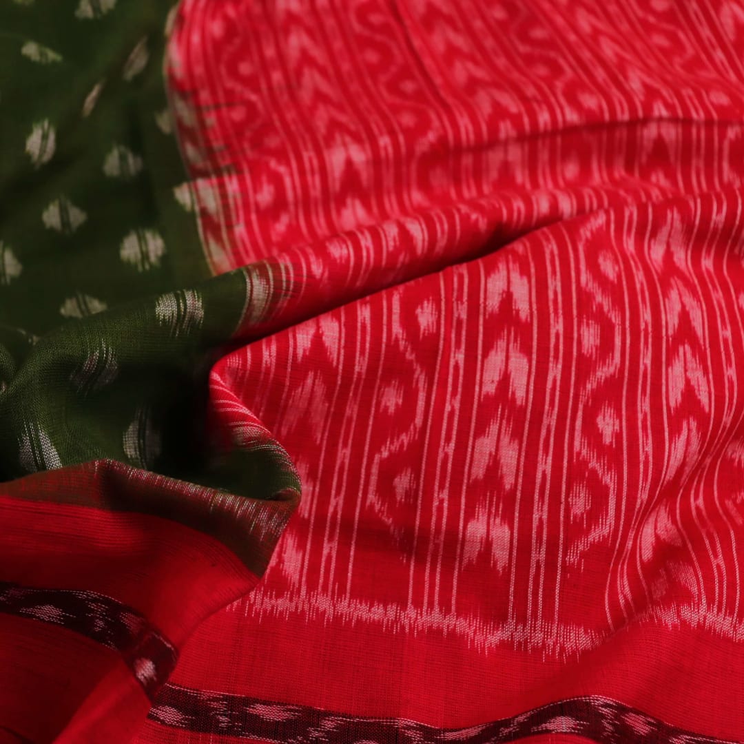 A woman wearing a green and red cotton Sambalpuri dupatta with motifs draped over her shoulder