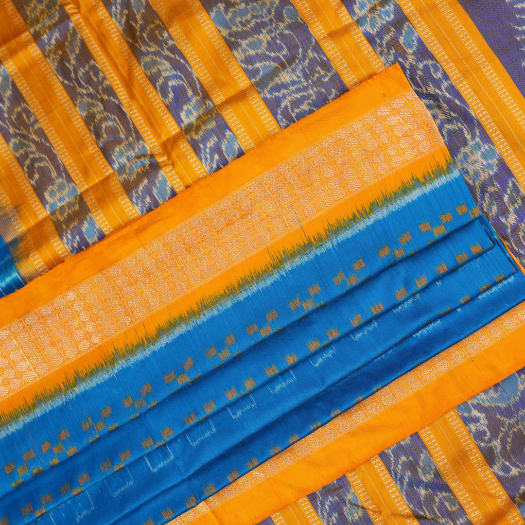 Close-up of the luxurious Sambalpuri silk fabric, highlighting its rich texture and handloom weave in blue and yellow.