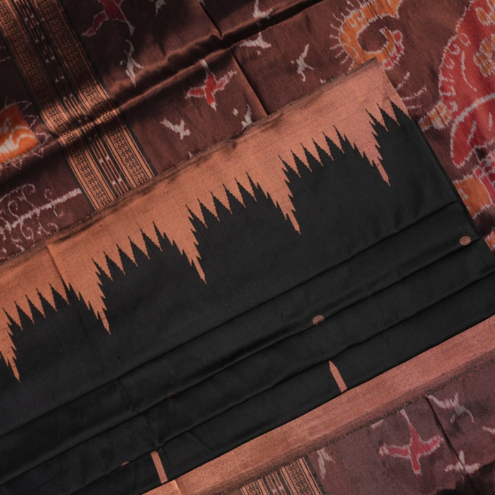 Extreme close-up showing the rich black and brown Sambalpuri Silk fabric texture and intricate handloom weave.