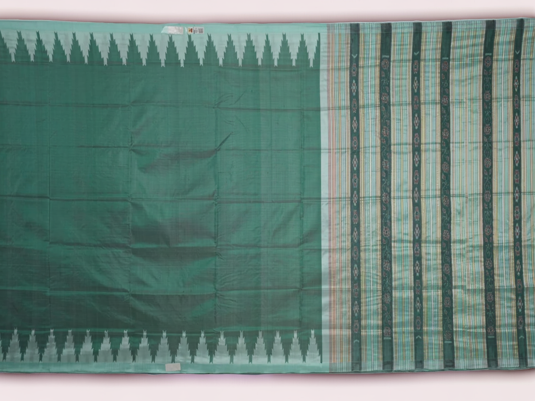 Extreme close-up of the green Sambalpuri silk fabric, revealing its luxurious texture and fine handloom weave.