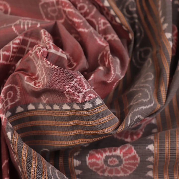 Close-up of a multicolored silk Sambalpuri saree fabric showing the intricate handloom texture and motifs.